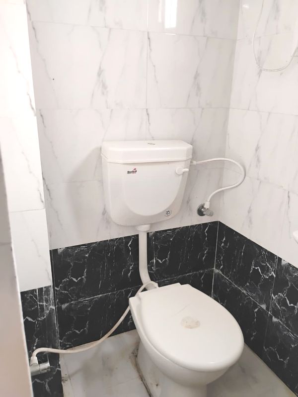 Clean and modern attached bathroom with hot water geyser at Radha Raman Residency